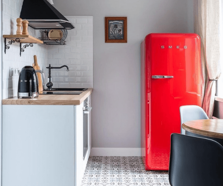 Кухня с красным холодильником и деревянной столешницей