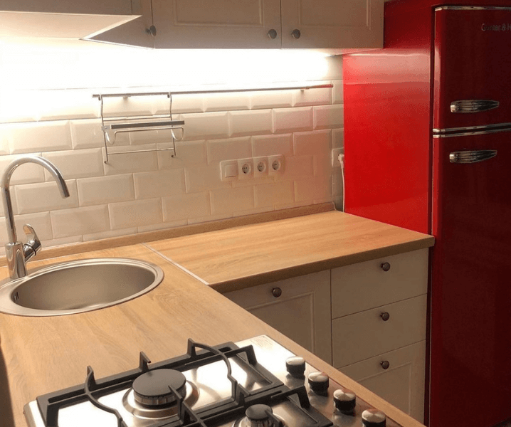 Кухня с красным холодильником и деревянная столешница