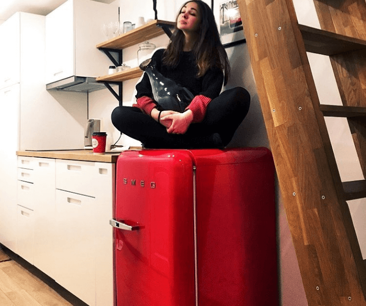 девушка на ярком холодильнике сидит