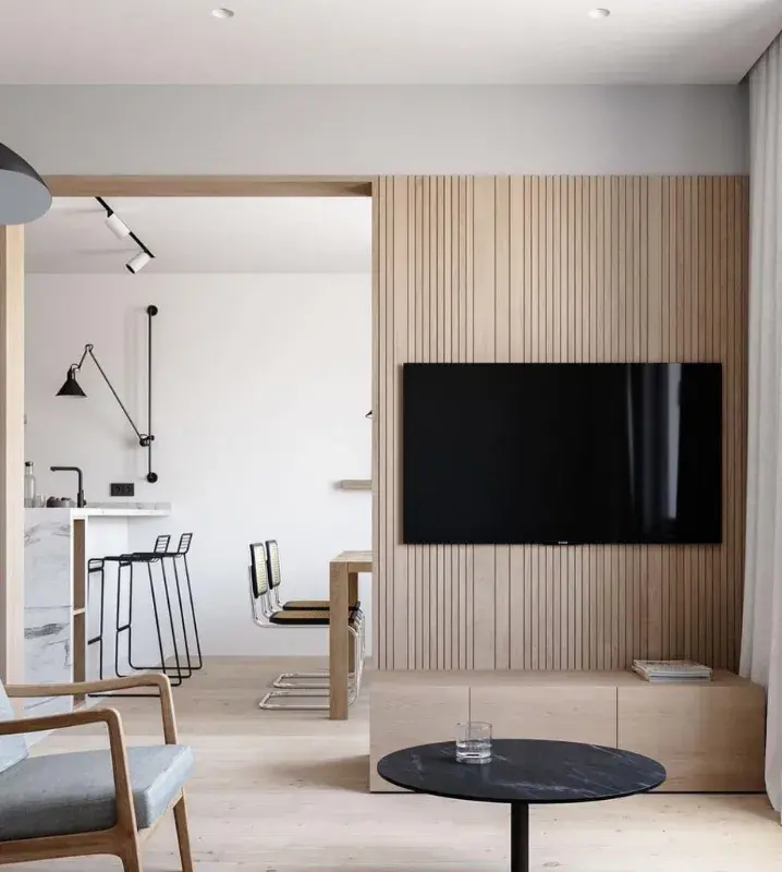 Интерьер небольшой кухни-гостиной с деревянной перегородкой и телевизором