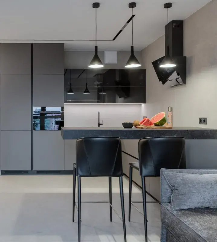 серый диван в интерьере кухни-гостиной с черными деталями