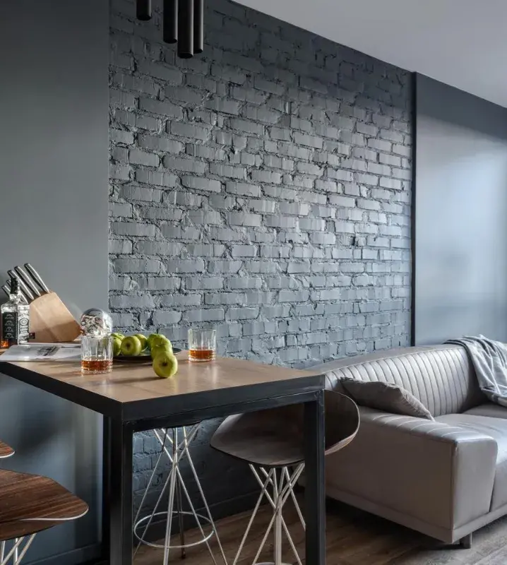 серый диван в интерьере кухни-гостиной с деревянной столешницей