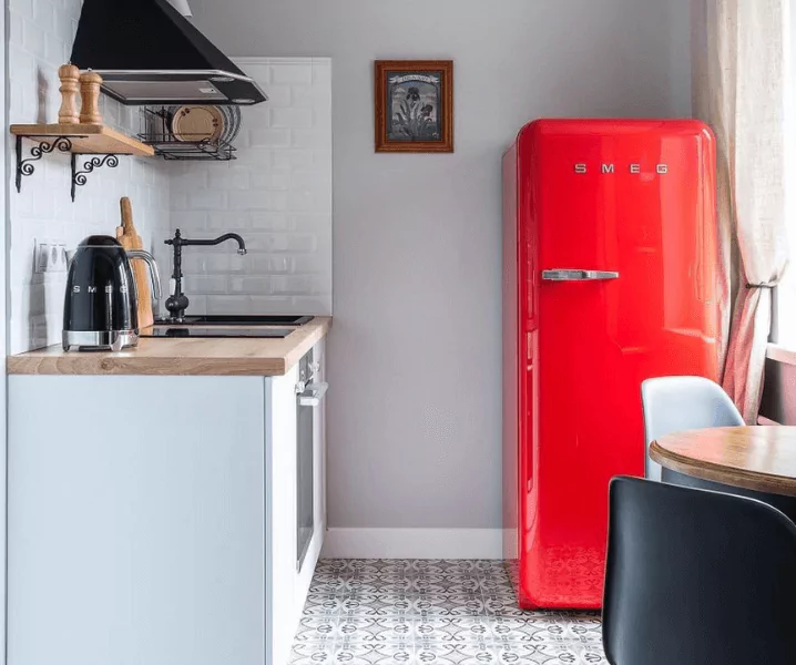 серый холодильник в интерьере белой кухни с деревянной столешницей фото
